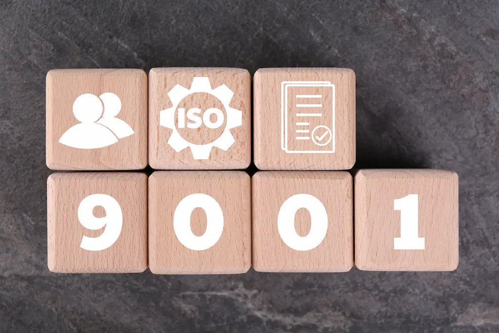 iso-9001-quality-management-systems-wooden-cubes-with-different-icons-grey-background-top-view